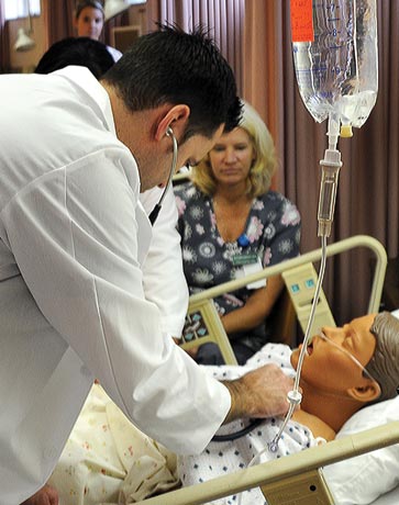male nurse taking vital signs on simulated patient