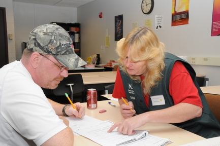 A tutor and a student sitting at a table, working.