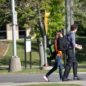 two students walking on campus in fall by kee hall