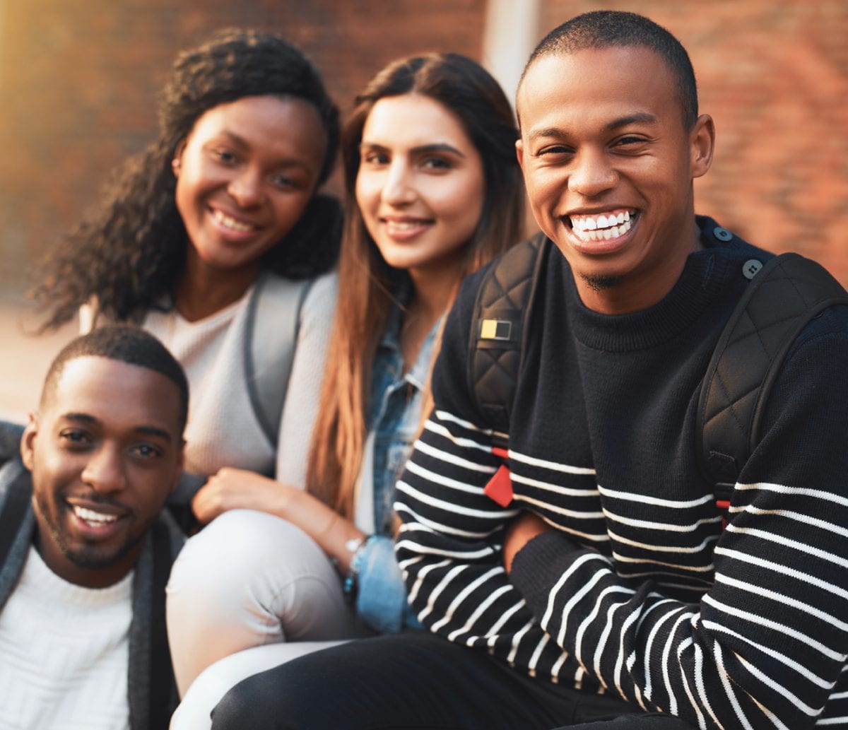 Portrait of a group of students relaxing together during a break on campus