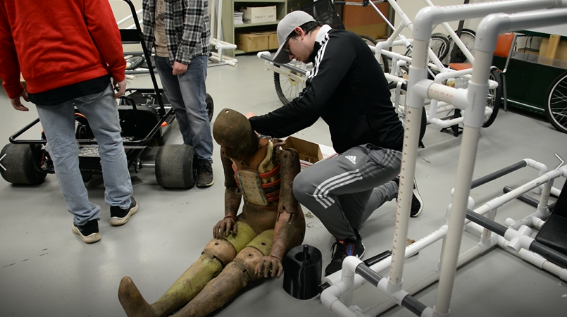 Nickolas Bowser examines the crash test dummy