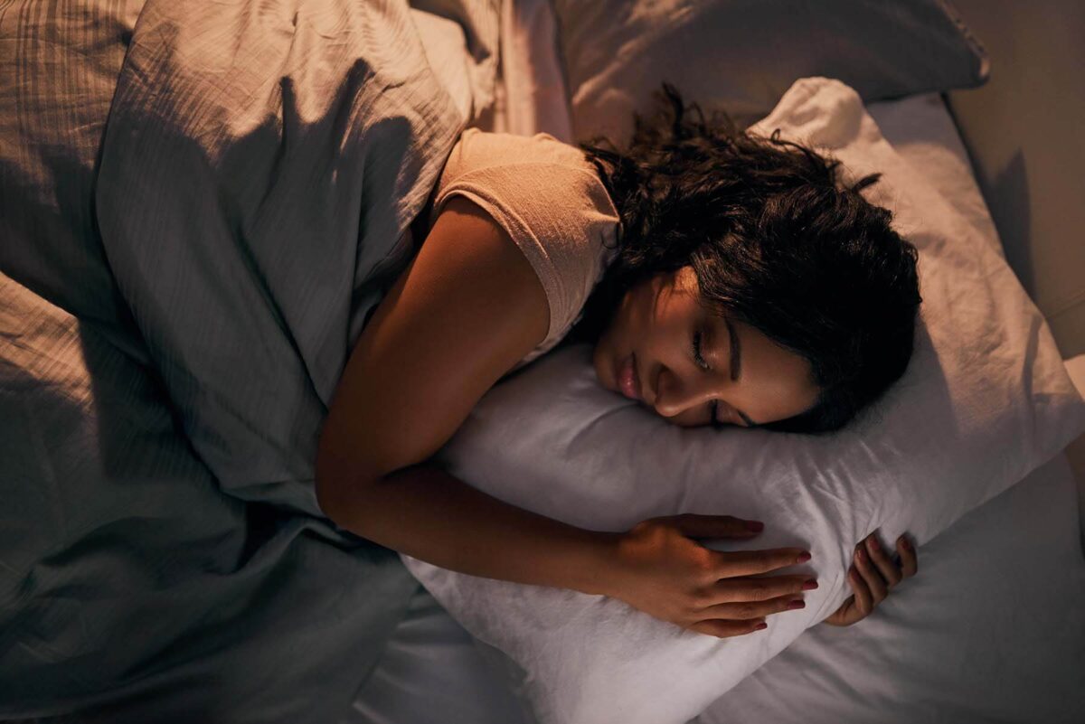 Young woman asleep in bed.