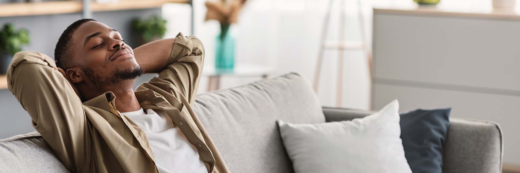 Guy relaxing with eyes closed sitting on sofa