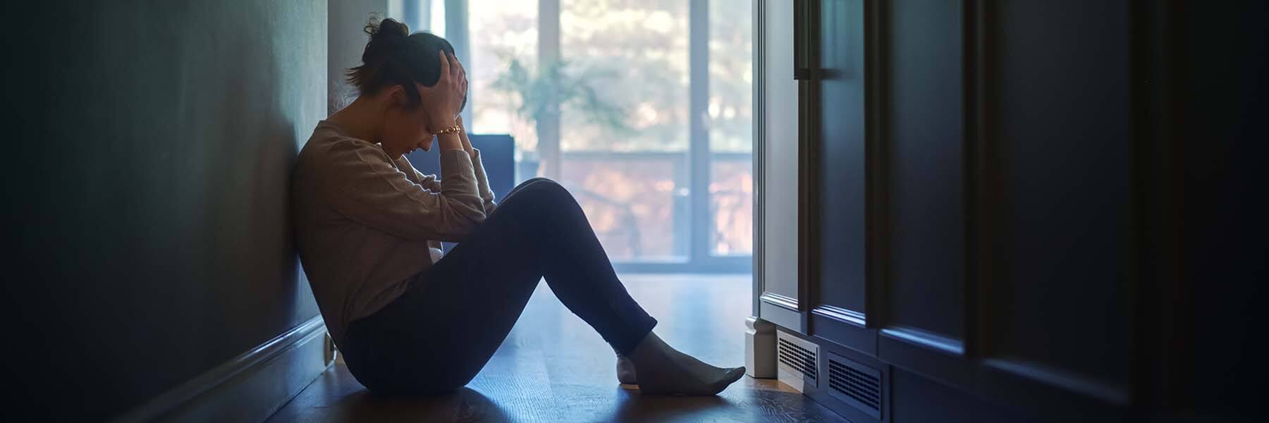 Depressed woman sitting on the floor