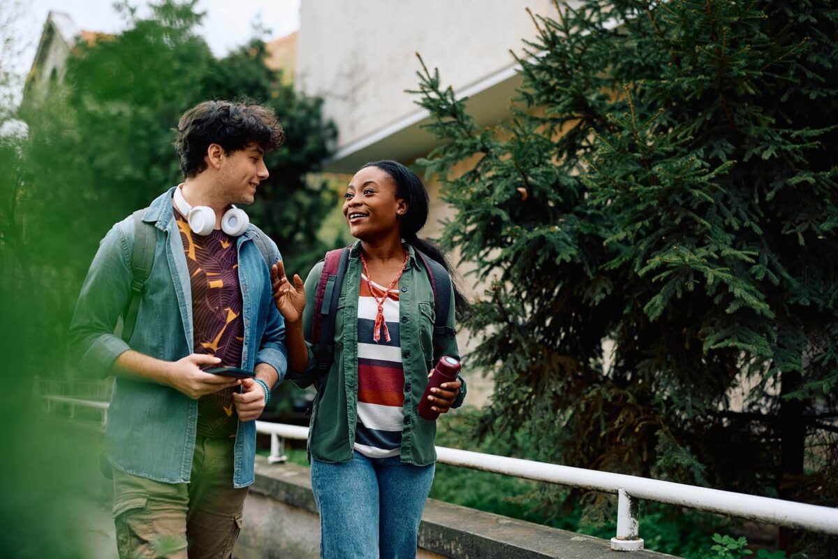 Two students walking outdoors and talking