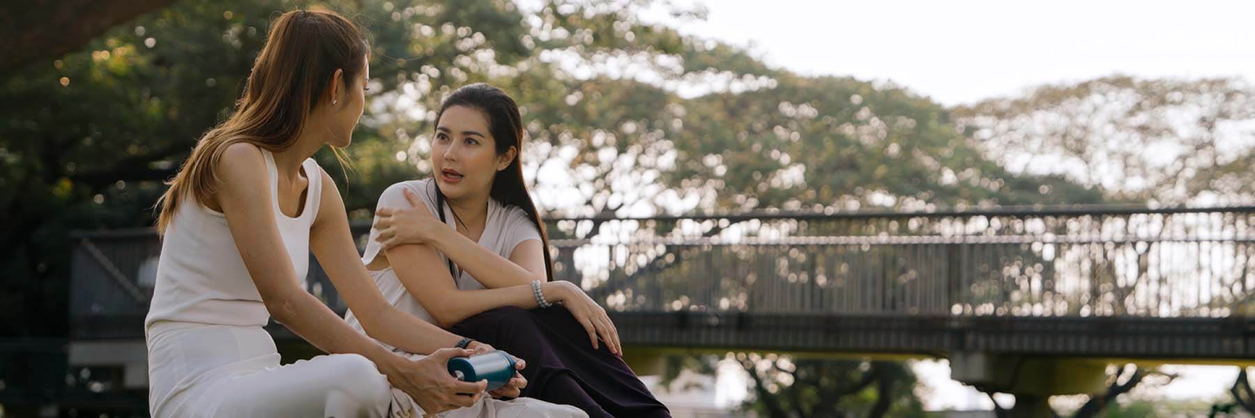 Two women sitting outdoors and talking