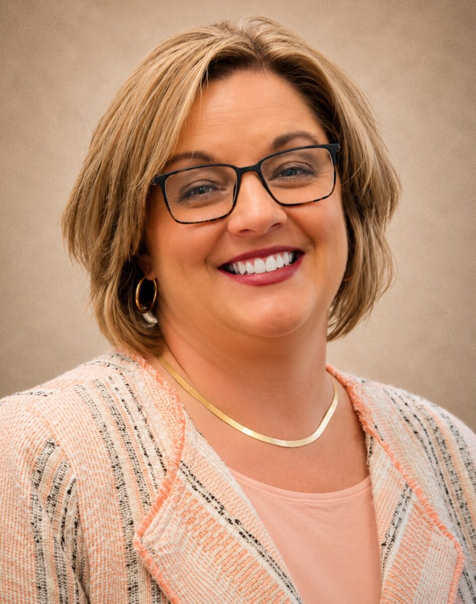 Woman with short hair and a gold necklace smiling