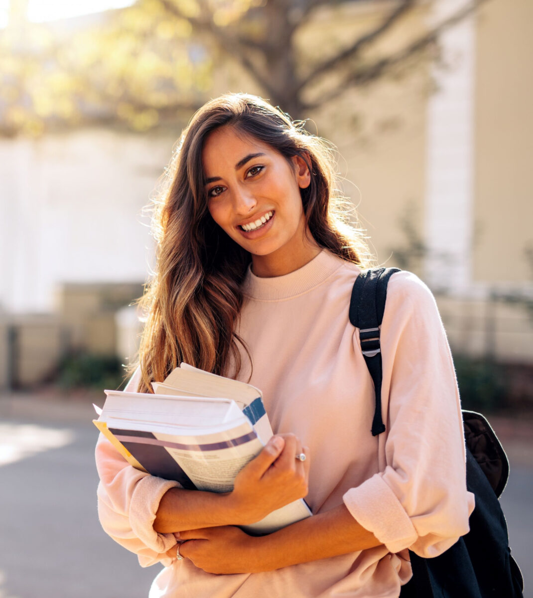 Happy student with books on campus