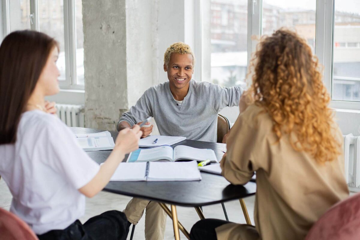Group of students sitting around a table and talking