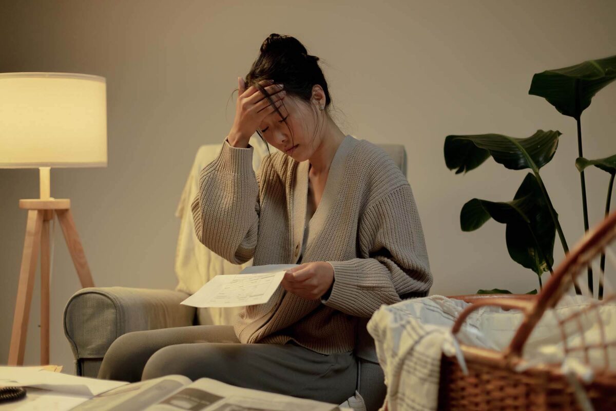 Worried young woman reading a bill statement